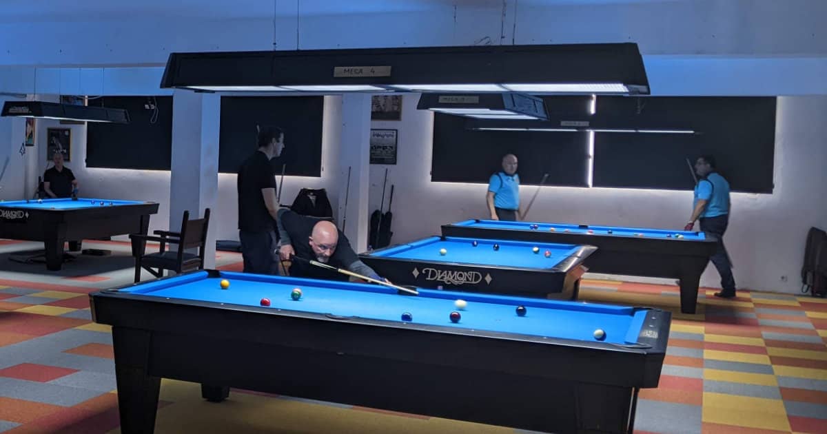Players taking turns at pool tables in a club
