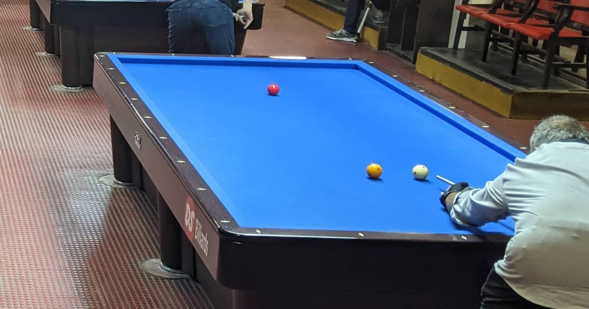 Player lining up a shot on a pocketless carom billiards table