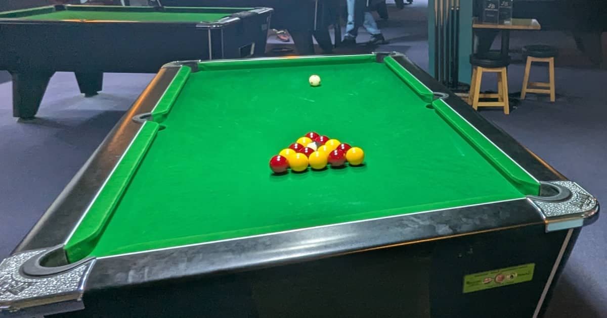 English pool table with red and yellow balls racked in a triangle